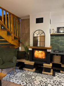 ein Wohnzimmer mit einem Kamin und einer Treppe in der Unterkunft Casa Rustik Nyaraló in Praid