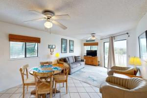 a living room with a table and a couch at Bay Creek Villa - 202 in Edisto Beach