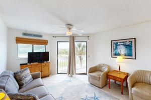 a living room with a couch and a tv at Bay Creek Villa - 202 in Edisto Beach