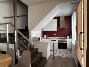 una cocina con una escalera que conduce a una cocina con paredes rojas en Casa Eliseo, en Los Yébenes