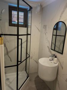 a white bathroom with a sink and a mirror at Paltin Evergreen Garana in Gărâna
