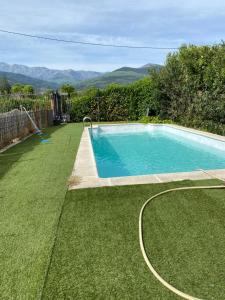 una piscina en un patio con césped verde en Los 11 Postes, en Candeleda