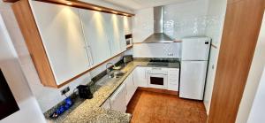 een keuken met witte kasten en een witte koelkast bij BRISA DE CALELLA DE PALAFRUGELL in Calella de Palafrugell