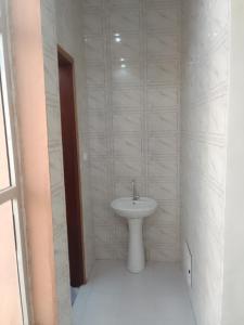 a white bathroom with a sink and a toilet at Appartement Meublé aux Almadies in Ngor