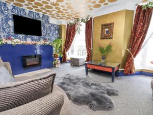 a living room with a couch and a tv at The Funky Flat in Holywell