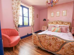 a bedroom with a bed and a chair and a window at The Funky Flat in Holywell