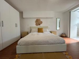 1 dormitorio con 1 cama blanca grande y armarios blancos en B&B La Bohème Porto Garibaldi, en Porto Garibaldi