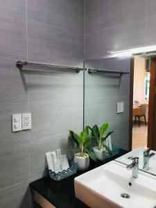 W łazience znajduje się umywalka i lustro. w obiekcie Kalia Hotel w Duong Dong