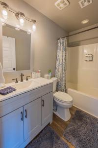 a bathroom with a sink and a toilet and a mirror at The Porch House in Stigler +19 photos