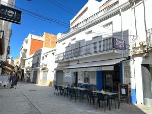 una calle con mesas y sillas fuera de un edificio en Agi Joan Badosa, en Roses