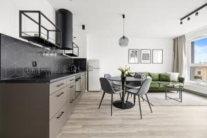 a kitchen with a table and a green couch at Serenity - Praia Apartments - Polsat Plus Arena Gdańsk in Gdańsk
