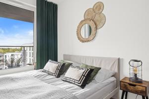 a bedroom with a bed with a mirror and a window at Serenity - Praia Apartments - Polsat Plus Arena Gdańsk in Gdańsk