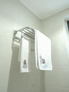 2 toallas colgando de un toallero en el baño en KIGALI DELIGHT HOTEL &APARTMENTS, en Kigali