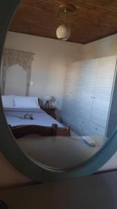 um quarto com uma cama e um espelho redondo em Olive holiday home em Laganas