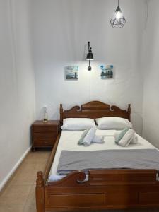 ein Schlafzimmer mit einem Holzbett mit zwei Kissen in der Unterkunft Το αρχοντικό της Ιωάννας ΙΙ in Apróvaton