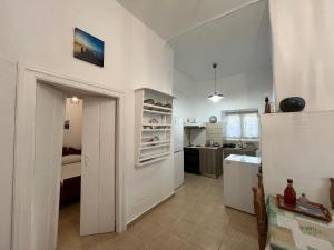 eine Küche mit weißen Wänden und eine Tür zu einem Zimmer in der Unterkunft Το αρχοντικό της Ιωάννας ΙΙ in Apróvaton