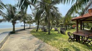 a beach with tables and chairs and palm trees at THANHLOI HOTEL in Mỹ Ðuc
