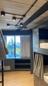 a bedroom with a bed and a large window at MONS hostel in Buenos Aires