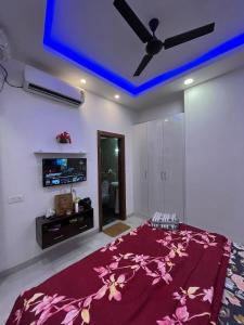 a bedroom with a bed with a purple blanket at Estates Model in Greater Noida
