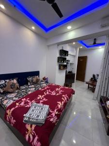 a bedroom with a bed and a blue ceiling at Estates Model in Greater Noida