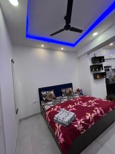 a bedroom with a bed with a blue ceiling at Estates Model in Greater Noida