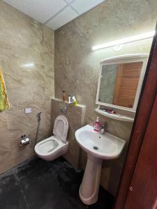 a bathroom with a toilet and a sink at Estates Model in Greater Noida