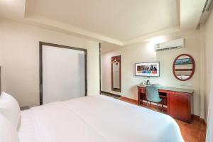 a bedroom with a bed and a desk and a mirror at Huahang Hotel - Guangzhou Baiyun International Airport - Free airport shuttle bus in Guangzhou