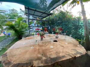 einen Holztisch mit Gläsern und Blumen darauf in der Unterkunft Jungle Bungalow with Small Pool in Talamanca