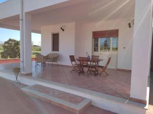 a house with a patio with a table and chairs at La Villetta in Cutrofiano