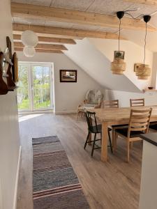 - une salle à manger et un salon avec une table et des chaises en bois dans l'établissement Nordgården - ferie på landet, à Skibby