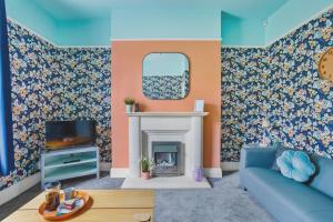 un soggiorno con un divano blu e un camino di Harbour Court Plymouth - Free Parking - tucked away on the Barbican with courtyard - by Ocean City Retreats a Plymouth