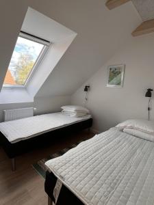 twee bedden in een kamer met een raam bij Nordgården - ferie på landet in Skibby