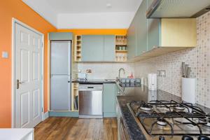 una cucina con fornello forno superiore accanto a un bancone di Harbour Court Plymouth - Free Parking - tucked away on the Barbican with courtyard - by Ocean City Retreats a Plymouth