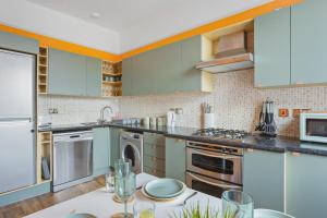 una cucina con armadi verdi e tavolo bianco di Harbour Court Plymouth - Free Parking - tucked away on the Barbican with courtyard - by Ocean City Retreats a Plymouth Altre 43 foto
