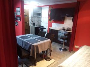 een kleine keuken met een tafel in een kamer bij Apartament Rosso in Kielce