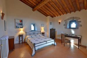 Schlafzimmer mit einem Bett, einem Tisch und einem Schreibtisch in der Unterkunft La Torre Vecchia in Castelnuovo Berardenga