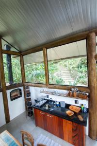 パラチにあるCasa do lenhadorの大きな窓のあるツリーハウスのキッチン