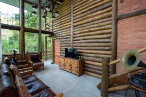パラチにあるCasa do lenhadorのリビングルーム(丸太の壁付)