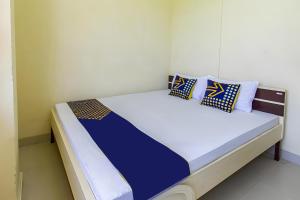 a bed with blue and white pillows on it at OYO Life 93399 Kos Batulayar in Senggigi