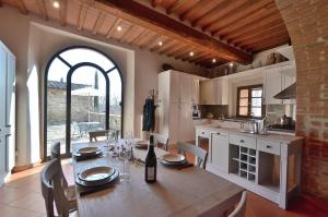 a kitchen with a wooden table and a dining room at Vin Santo in Castelnuovo Berardenga