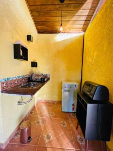 uma cozinha com um lavatório e um telefone num quarto em Rancho Ubuntu em Brumadinho