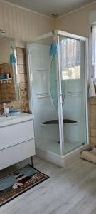 ein Bad mit einer Dusche und einer Glastür in der Unterkunft Maison Colleville-Montgomery - Bord de mer in Colleville-Montgomery