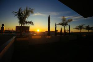 zachód słońca z palmami w obiekcie Pousada Sol Pato Branco w mieście Pato Branco