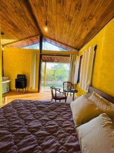 a bedroom with a large bed and a table at Rancho Ubuntu in Brumadinho