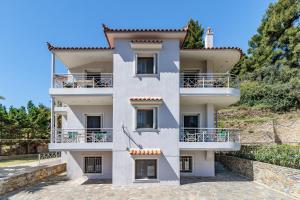 un edificio bianco con balconi su una collina di Likasti a Skopelos Town