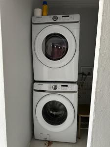 Duas máquinas de lavar e secar roupa num quarto em Spacious Unit with 5BR, 3BA Perfect for Big Groups, Near Ocean Park Beach em San Juan