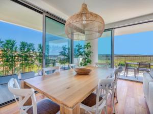 Un comedor con mesa y sillas de madera. en Bayline - Beachfront Bliss & Spa by Bedzy, en Armação de Pêra