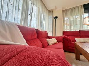 a living room with a red couch and a red blanket at El Patuco - 6821 in Noja