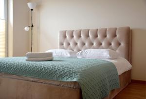 a bedroom with a large bed with a large headboard at Green Acres Apartment in Palanga