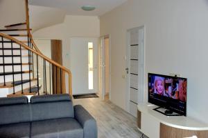 a living room with a couch and a tv at Green Acres Apartment in Palanga